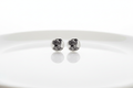 Round white stud earrings with black illustrated character design