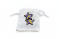Purple and yellow cow print star-shaped resin earrings on white satin pouch