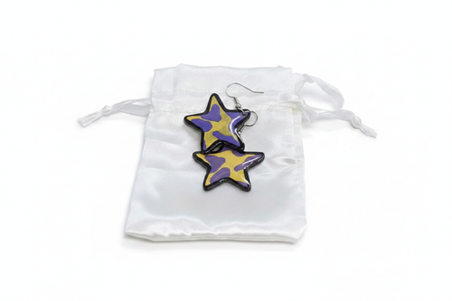 Purple and yellow cow print star-shaped resin earrings on white satin pouch